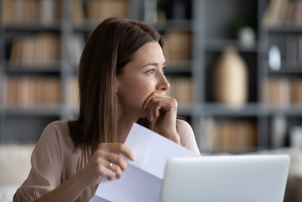 Depressed woman worrying about bad news notice.